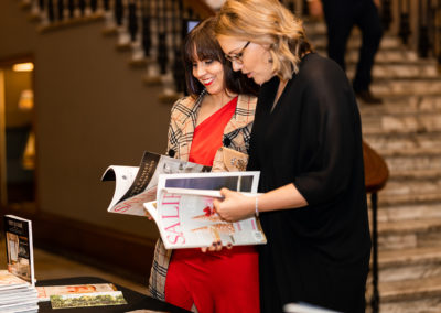 Guests reading SALIFE magazines on a table display at SALIFE Absolute Best Awards